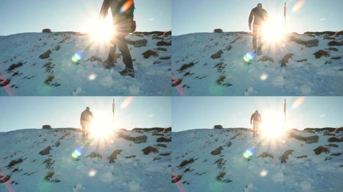 男性徒步旅行者在冬天的雪山中攀登