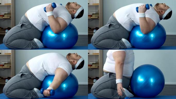 有动力的胖男举哑铃躺在健身球上，减肥计划