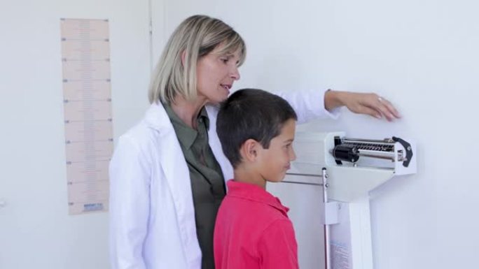 营养师医生测量男孩病人的身高和体重