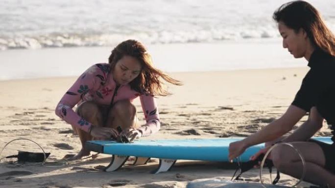 亚洲华人妇女在海滩上戴上腿冲浪皮带或腿绳去冲浪台湾的海浪