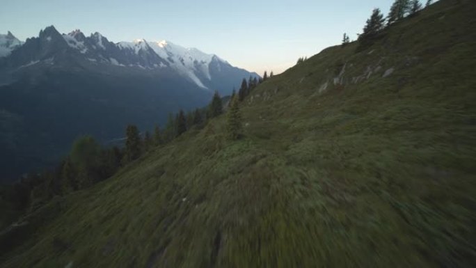 空中无人机在日落时在山上的一座小山上射击