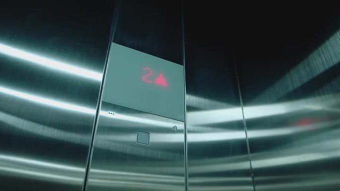 现代乘客电梯的客舱。数字电梯记分牌，显示楼层号码。电梯中的数字显示，在地板上上升，箭头向上。电梯上到