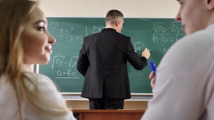 学生交谈并干扰课程。老师在黑板上写公式