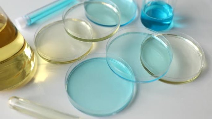 实验室用浅蓝色液体和油的各种玻璃器皿和试管