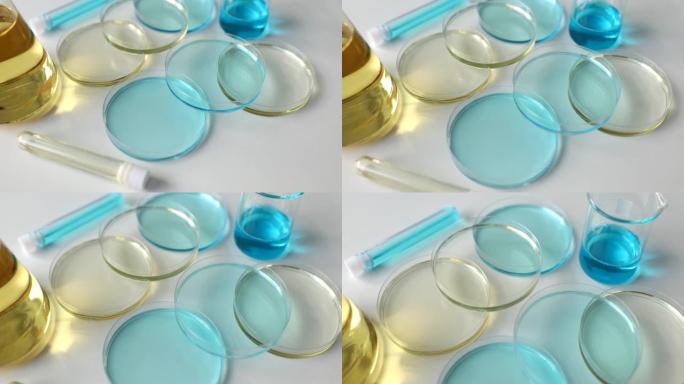 实验室用浅蓝色液体和油的各种玻璃器皿和试管