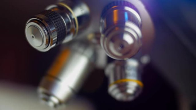 显微镜的目标在深色背景上照射铬表面