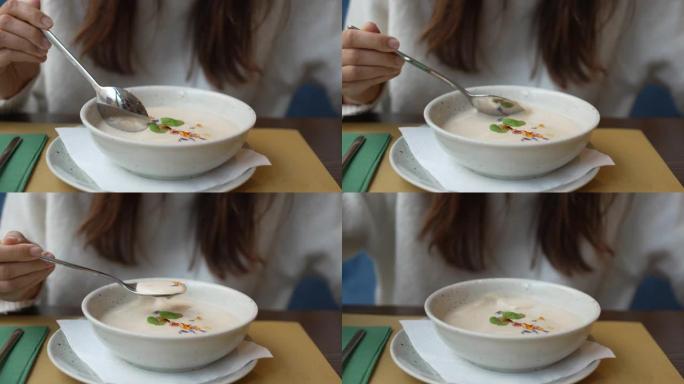 一个女人吃白奶油汤的特写镜头