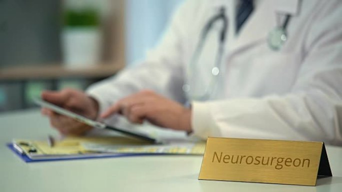 男性神经外科医师在临床上观察平板电脑的MRI测试结果，并报告分型