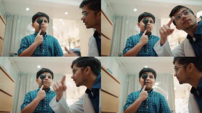 印度男孩在仪器上检查眼科医生的眼睛