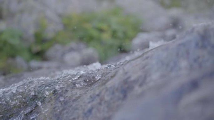 在岩石山坡上流水的详细镜头