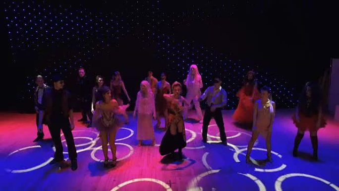 穿着鲜艳服装的演员在色彩缤纷的舞台上跳舞和唱歌