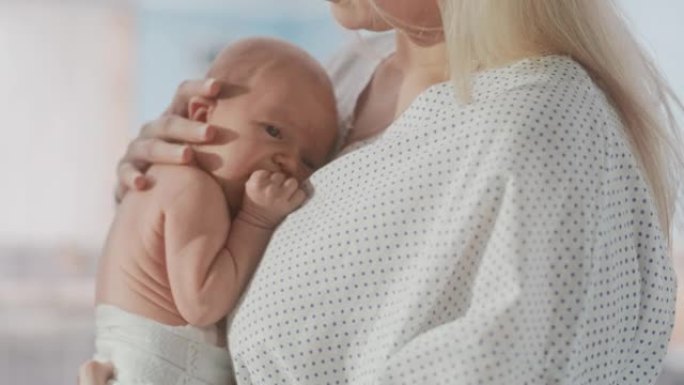 一位母亲抱着她的新生儿，在现代产科诊所与小婴儿建立联系。白人妇女抱着她的孩子。医疗保健、孕产和孕产概