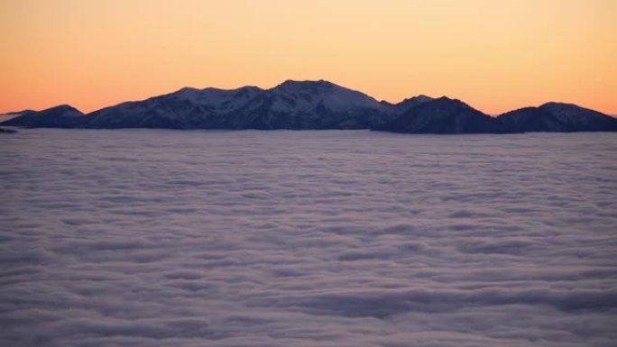 雪，云和雾在下面滚动的山脉的风景