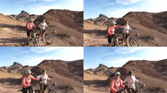 成熟的女性沿着沙漠小径骑自行车，停下来欣赏风景