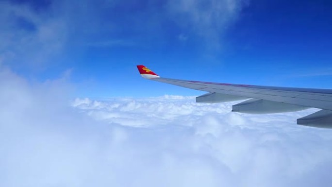 香港。香港航空公司的机翼在座位上眺望，看着窗外的乌云和蓝天。