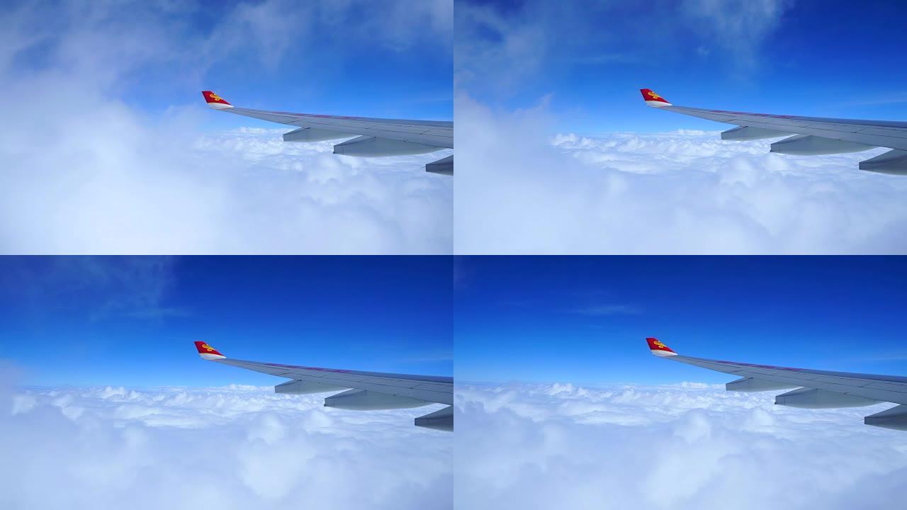 香港。香港航空公司的机翼在座位上眺望，看着窗外的乌云和蓝天。