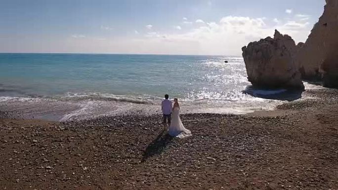 与岩石对抗大海的新婚夫妇的肖像