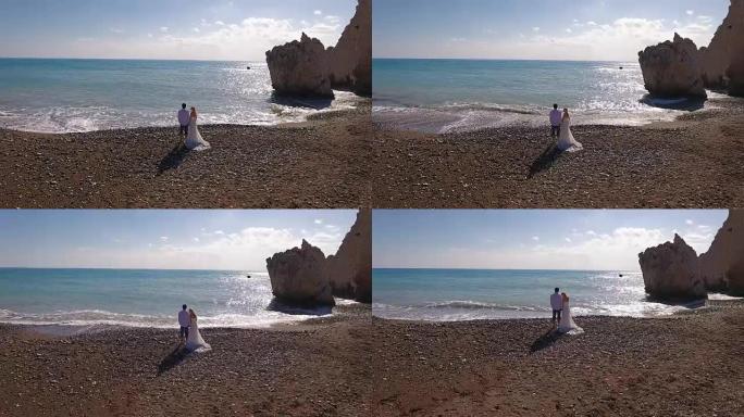 与岩石对抗大海的新婚夫妇的肖像