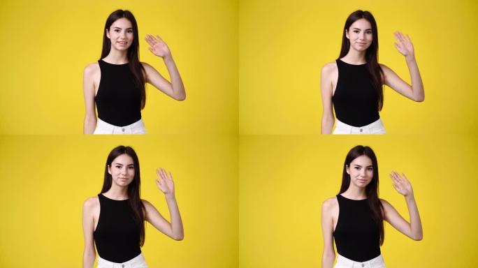 黄色背景上可爱的女孩挥手打招呼的4k视频。