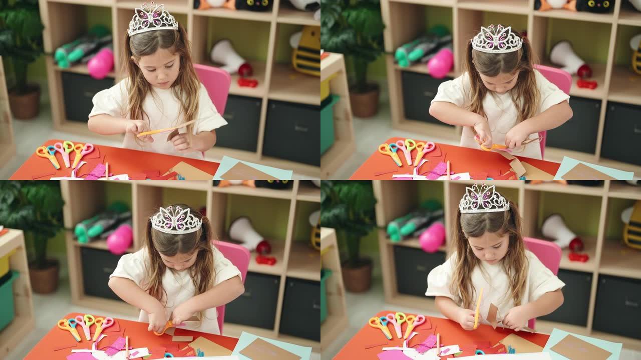 可爱的金发女学生在幼儿园戴着公主皇冠剪纸