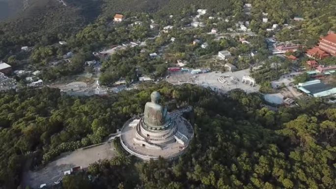 游客在树木中著名的佛陀纪念碑上的空中平移镜头，无人机飞越nea雕像