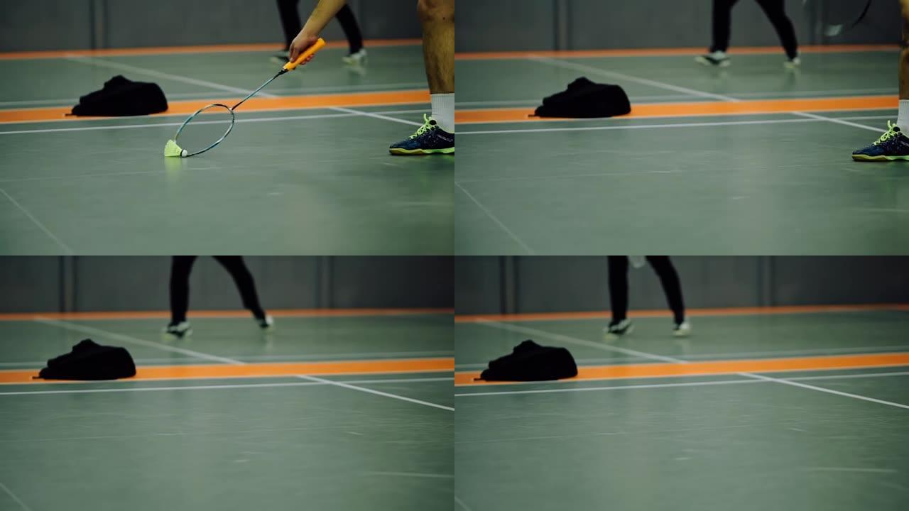 羽毛球运动员使用球拍投掷羽毛球。