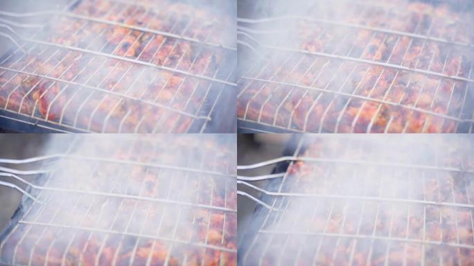 肉是在烟雾特写下烹饪的，视差。鸡翅在烤架上的网格中，相机运动平稳