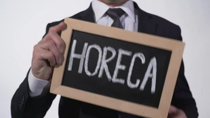 HoReCa写在商人手中的黑板上，餐饮服务业