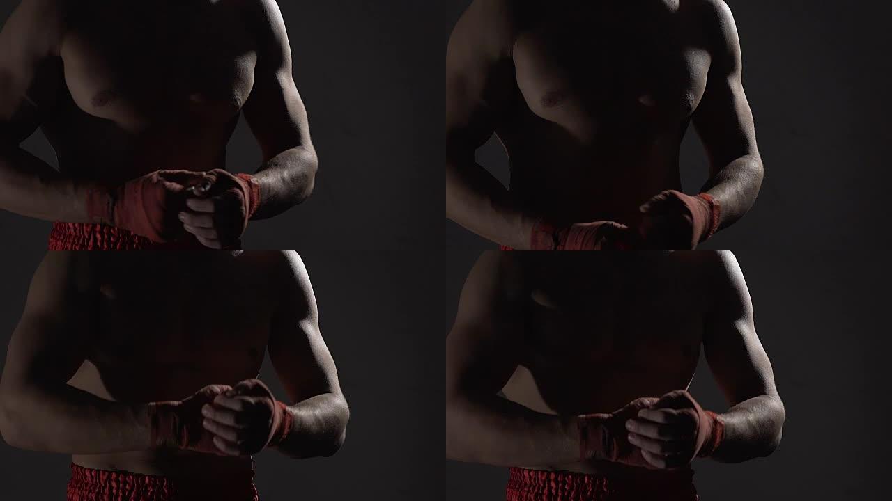 强壮的男拳击手在健身房拳击前用拳头握拳，慢动作