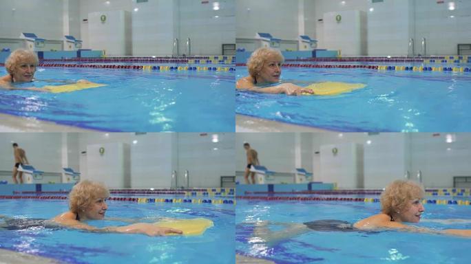 老年妇女用特殊设备在游泳池游泳