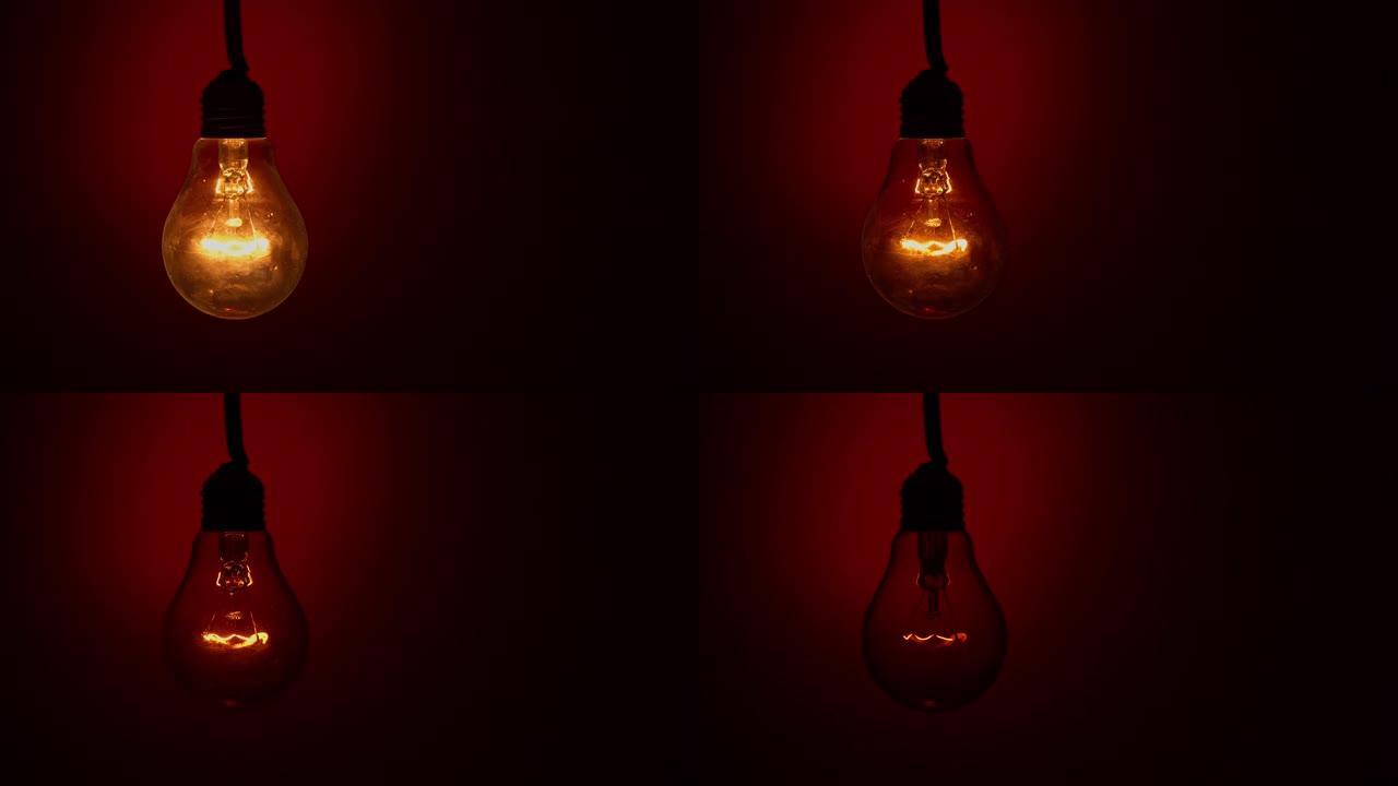 灯泡在黑暗中的红色背景下熄灭