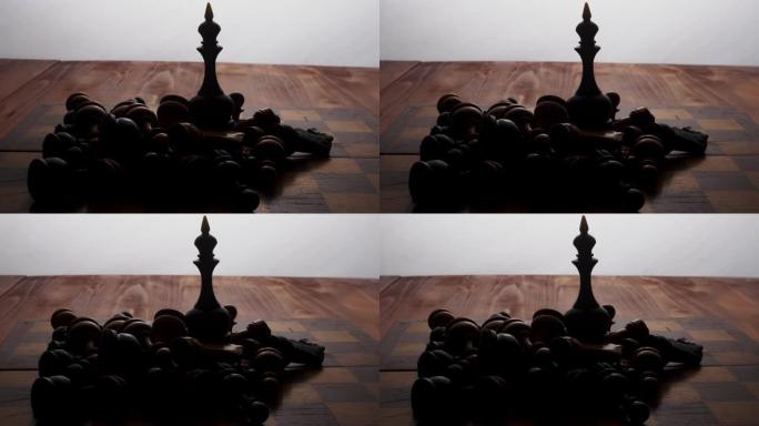 国际象棋黑皇后站在棋盘上，被其余的躺着的棋子包围着。棋盘游戏。摄像机沿着物体移动