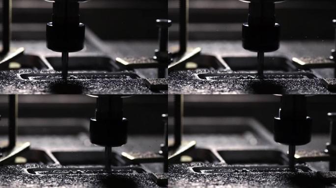 公司中的机器人在编写的用于与钢一起工作的程序的帮助下，用慢动作的钻头从铝板上切下。金属屑向不同方向飞