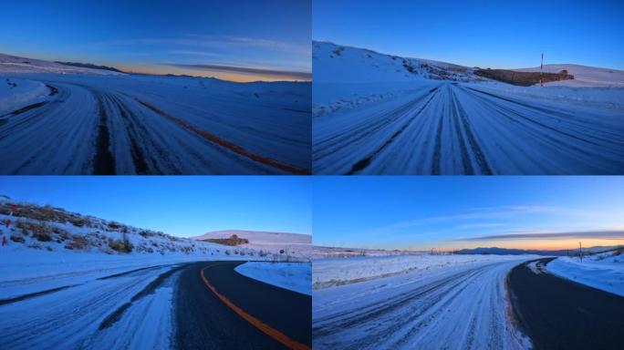 黄昏时在雪山路上行驶。