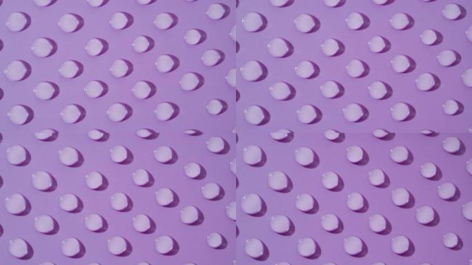 紫色背景上移动透明液滴的俯视图宏