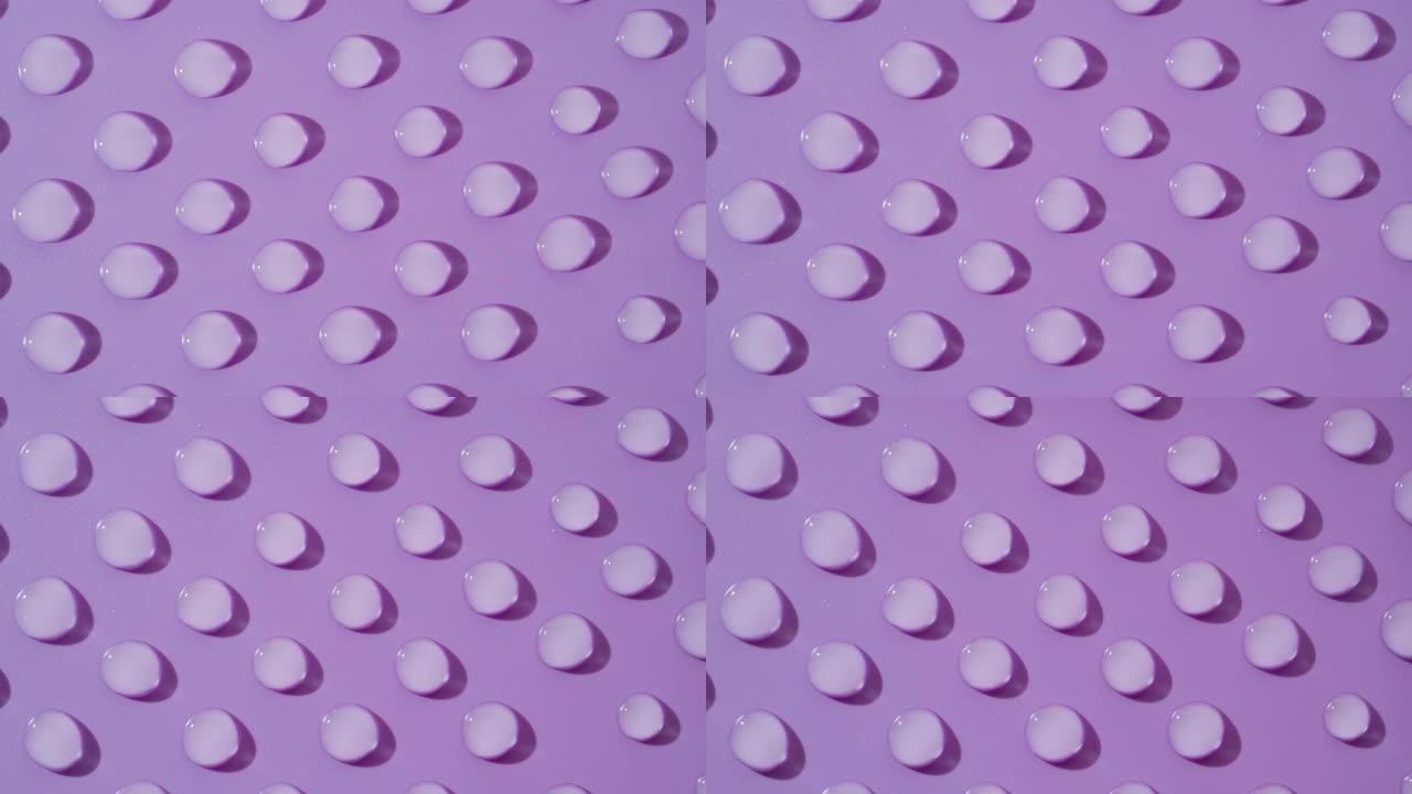 紫色背景上移动透明液滴的俯视图宏