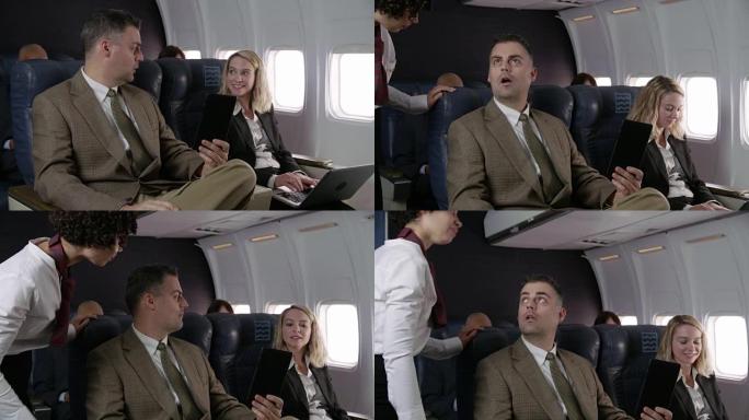 空姐在飞机上与乘客交谈