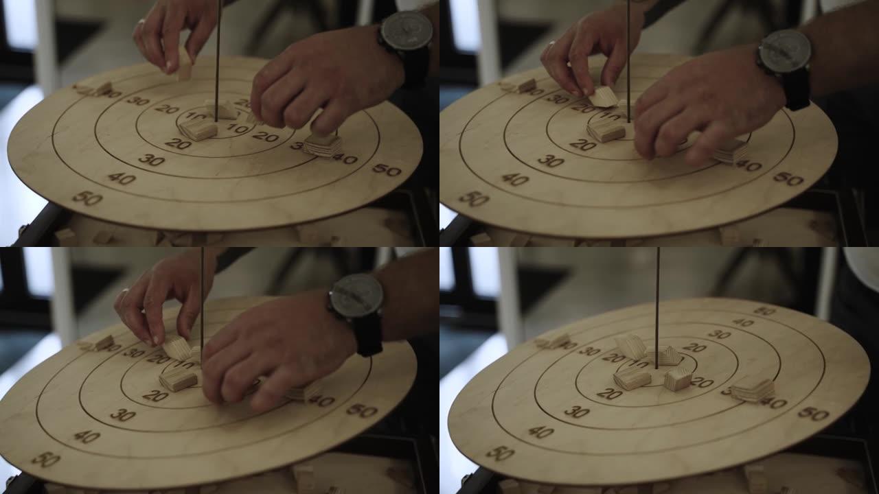 男性的手把两个木块放在游戏平衡器的圆圈上。
