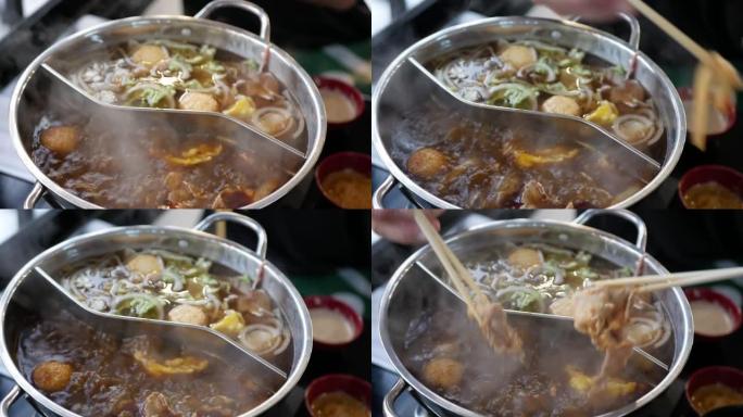 中国辣火锅菜，同时在热煮的中国式汤底中烹饪肉丸，鱼丸和肆意