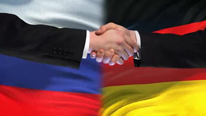 俄罗斯与德国握手，国际友谊峰会，旗帜背景