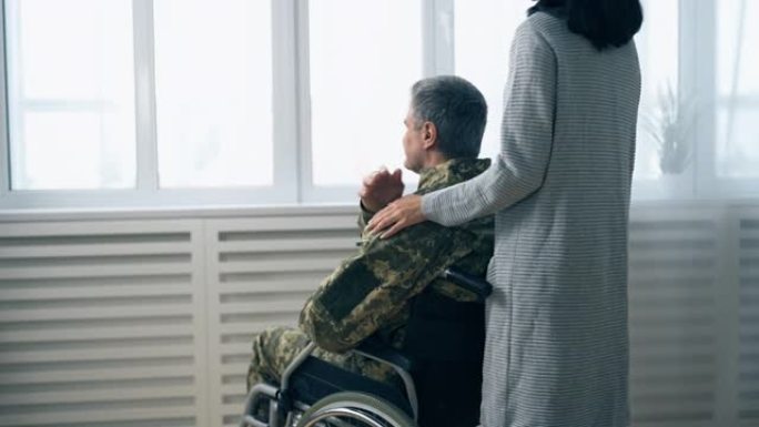 妻子支持她残疾的军人丈夫和家人的背影
