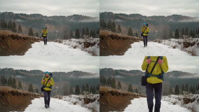 男性徒步旅行者在冬天的雪山中攀登