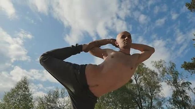 蓝天背景下的运动员在练习瑜伽