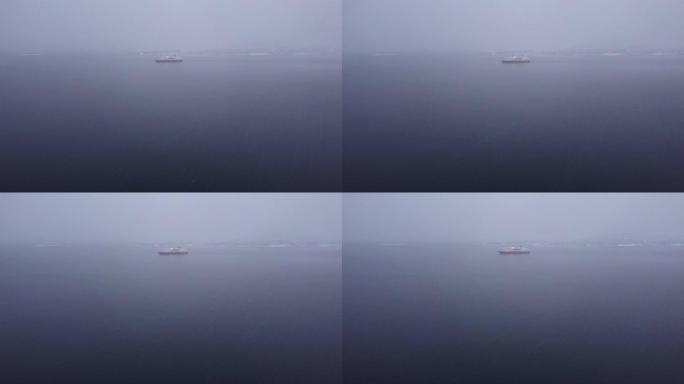 在阴沉的雾天，在海中远处的游艇
