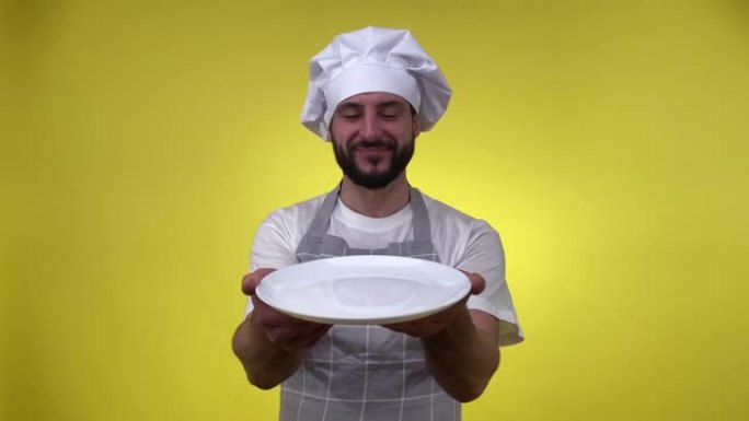 厨师拿着白色的空盘子高兴地闻到黄色孤立的好气味