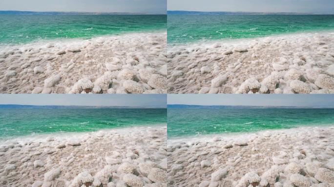 史诗般的死海海滨，白色的盐晶体和蓝色清澈的盐水靠近以色列和佩特拉，这是联合国教科文组织在约旦的红岩砂