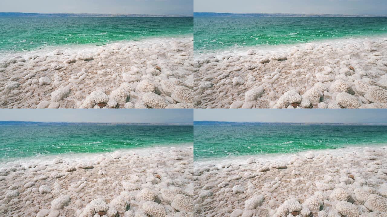 史诗般的死海海滨，白色的盐晶体和蓝色清澈的盐水靠近以色列和佩特拉，这是联合国教科文组织在约旦的红岩砂
