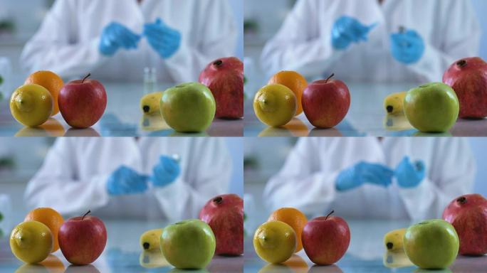 研究桌上的新鲜水果，实验室工作人员开发维生素精华，转基因食品