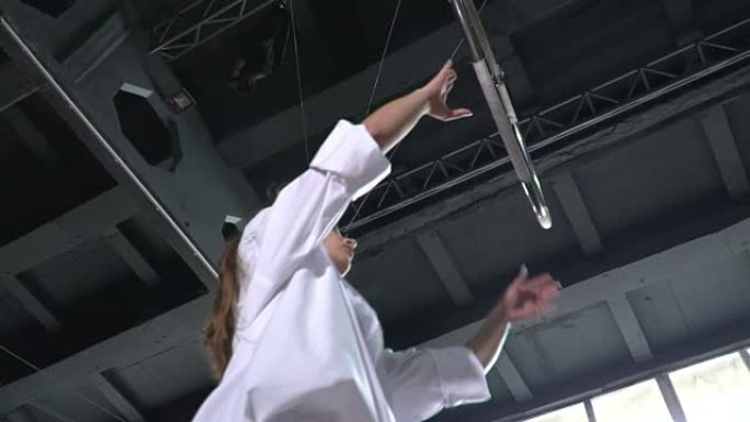 柔韧的体操运动员在空中环上用慢动作表演一个戏法