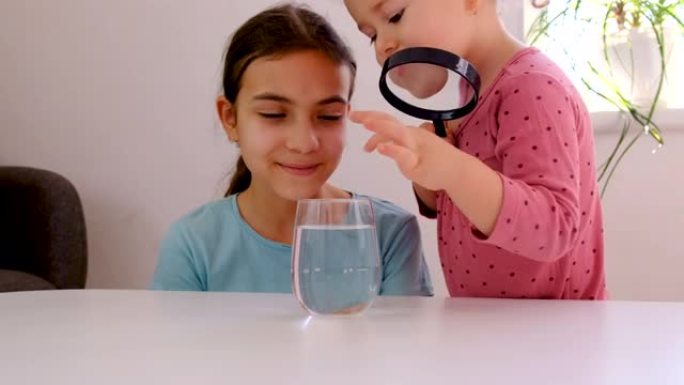 那孩子用放大镜观察水。有选择性的重点。孩子。